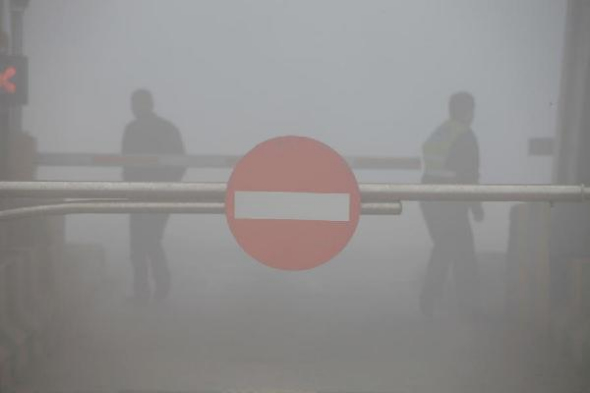 A tollgate on the Ji-Cao Expressway is closed due to heavy smog, in Jilin, northeast China's Jilin Province, Oct. 22, 2013. Heavy smog lasted into the second day on Tuesday in northeast China, causing a poor visibility. (Xinhua)