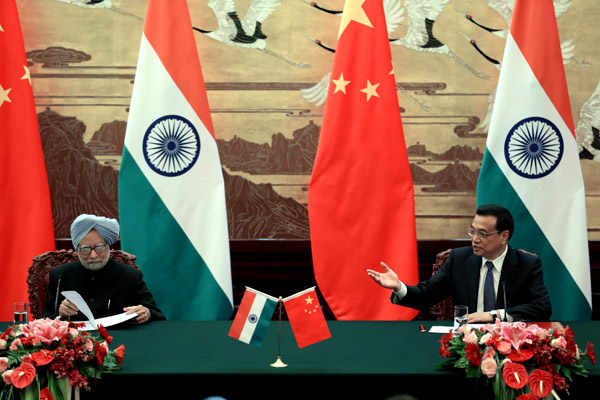 Premier Li Keqiang (right) and visiting Indian Prime Minister Manmohan Singh attend a media session at the Great Hall of the People in Beiing on Wednesday. Wu Zhiyi / China Daily