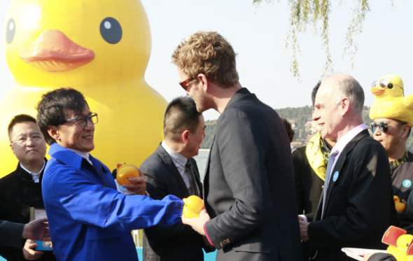 Dutch artist Florentijn Hofman (center, front row) and movie star Jackie Chan gather with others at the Summer Palace on Thursday to bid farewell to the Rubber Duck. The inflatable, designed by Hofman, ends its Beijing tour on Sunday after being on display for nearly two months at two venues in the capital. [Photo by Feng Yongbin / China Daily]