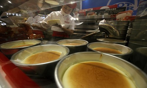 Shop assistants make cakes at the RIKURO bakery in the Rel Department Store on Nanjing Road West Thursday. Photo: Cai Xianmin/GT