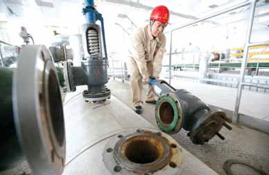 A worker examines and fixes a gas-powered boiler in a community in Beijing. The capital is making efforts to replace coal-fired boilers for heating to reduce pollution during winter. Fu Ding / for China Daily