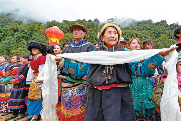 Tibetans in traditional clothing and holding hada — a scarf-like white silk for blessings — celebrate the opening of a 117-km highway linking Medog, the last roadless county in China,with neighboring Bome county in the Tibet autonomous regionon Thursday. Construction of the highway, which cost 950 million yuan ($155 million), started in April 2009. [Photo by Li Lin/China News Service]