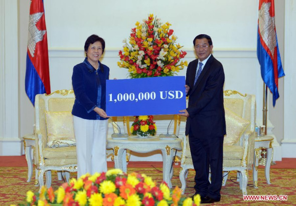 Cambodian Prime Minister Hun Sen (R) and Chinese Ambassador to Cambodia Bu Jianguo pose for photos in Phnom Penh, Cambodia, Oct. 31, 2013. China on Thursday donated one million US dollars to Cambodia for the relief of the flood-affected people. (Xinhua/Sovannara)