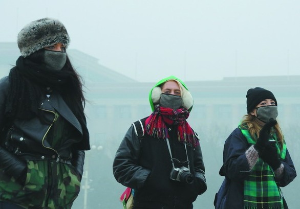 Foreign tourists wearing face masks visit the Tiananmen Square in heavy smog in Beijing, China, 29 January 2013. [File photo/China Daily]  