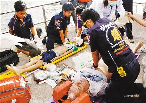 Salvagers give emergency treatment to injured foreign tourists after a ferry sank near Thailand's tourist resort of Pattaya on Sunday. [Photo: Chongqing Daily]