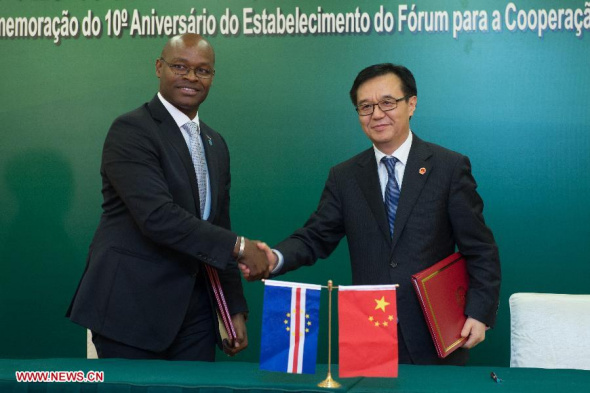 Chinese Minister of Commerce Gao Hucheng (R) shakes hands with Humberto Brito, minister of tourism, industry and energy of Cape Verde, after signing bilateral documents concerning economic and technological cooperation between the two countries in Macao, south China, Nov. 4, 2013. (Xinhua/Cheong Kam Ka)