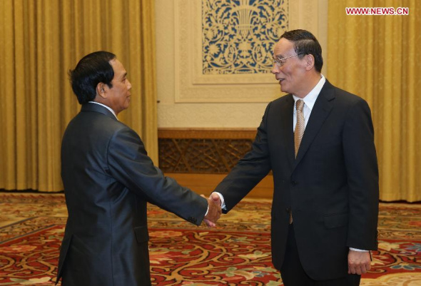 Wang Qishan (R), a member of the Standing Committee of the Political Bureau of the Communist Party of China (CPC) Central Committee and secretary of the CPC Central Commission for Discipline Inspection, meets with a delegation led by his Lao counterpart Bounthong Chitmany, president of the Central Control Committee of the Lao People's Revolutionary Party (LPRP) in Beijing, capital of China, Nov. 5, 2013. (Xinhua/Liu Weibing) 