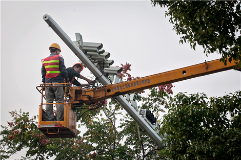Workers are seen removing surveillance cameras yesterday in Baoshan District, where rows of surveillance cameras over a road sparked controversy recently. (Sun Zhan) 
