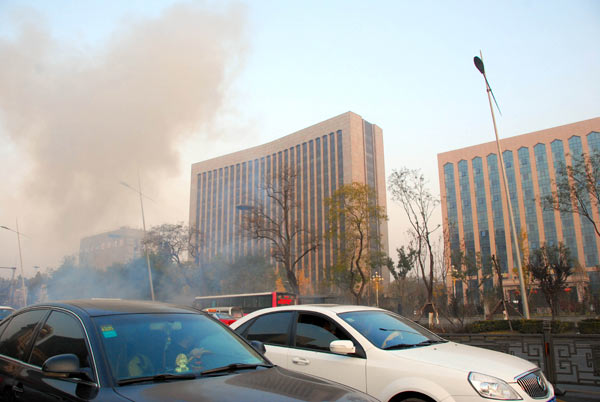 Smoke rises near the office building of the Shanxi provincial Party committee in Taiyuan on Wednesday. Police are investigating the bomb blasts that killed one and injured eight. Liu Guoliang / Xinhua