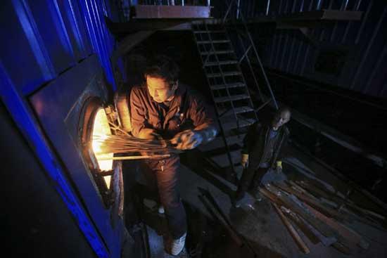 Workers ignite a boiler of a residential district in Changping, Beijing. Beijing kicks off its trial heating on Nov 7 and about 50% of its heating units are expected to ignite. [Photo by Fu Ding/Asianewsphoto]