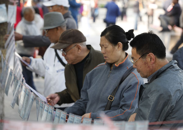 Seniors read information posted at a matchmaking party in Qingdao, Shandong province. The party attracted more than 2,000 people who were looking for partners. Zhang Lei / for China Daily