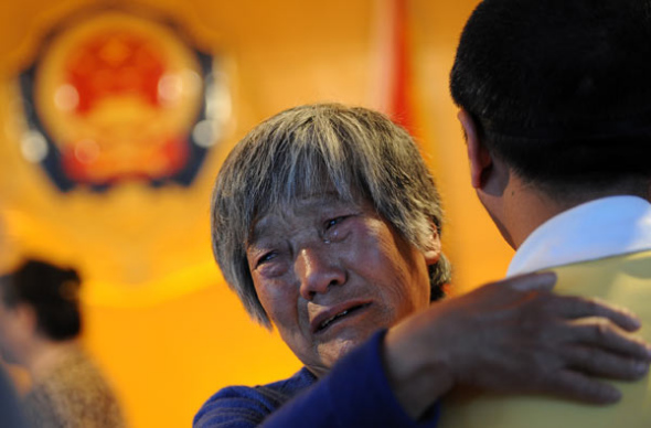 A woman gets emotional when meeting her son receiving reeducation through labor in Taiyuan, Shanxi province, May 10, 2013. [Photo by Deng Deng/Asianewsphoto] 