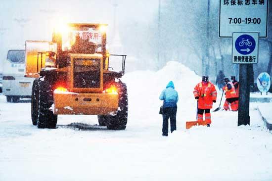 Trucks and workers shovel snow on the streets of Harbin, Northeast China's Heilongjiang province, Nov 18, 2013. [Photo/Xinhua]