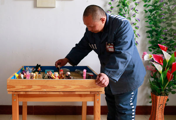 A prisoner uses sandplay therapy to read his own mind at Jin Zhong Prison in Beijing. Feng Yongbin / China Daily