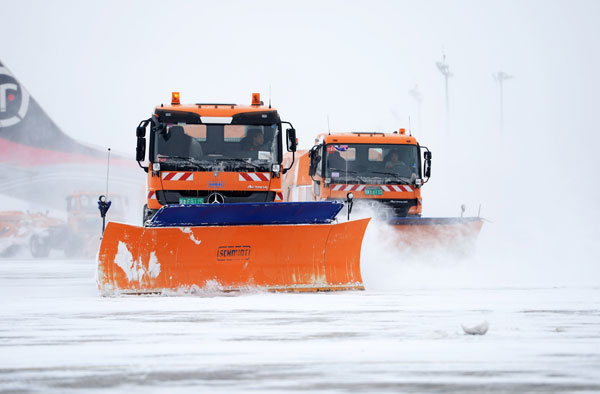 Snow plows working at Taiping International Airport in Harbin, which has remained operational despite the harsh conditions. [Photo/Xinhua]