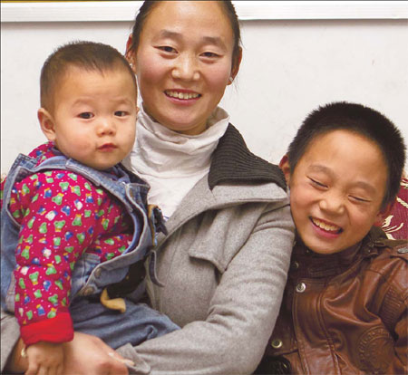 Chen Aihua enjoys having two sons, Wang Zichen (in her arms) and Wang Ziqin, 8 inYicheng county, Shanxi province, in this 2011 file picture. [Photo/China]
