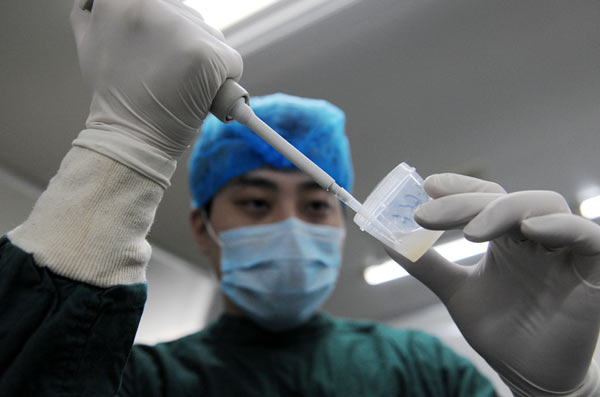 A doctor at a sperm bank in Zhengzhou, Henan province, prepares sperm for inspection. Li Bo / Xinhua