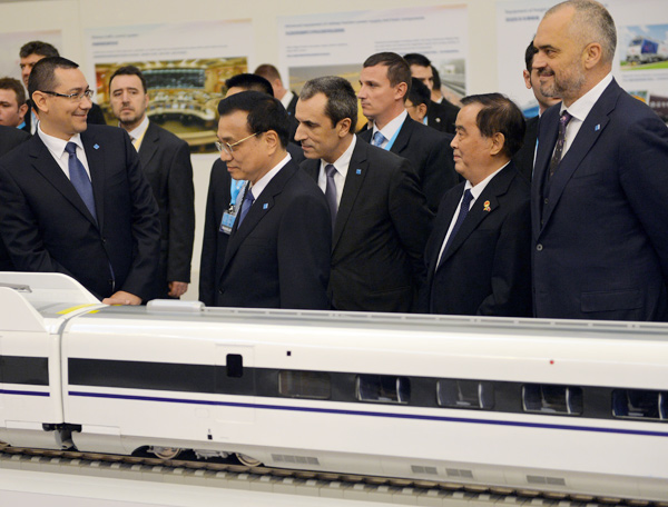 Premier Li Keqiang and leaders from Central and Eastern European countries view a model of a Chinese high-speed train at an exhibition of Chinese equipment in Bucharest, the Romanian capital, on Tuesday.[Xinhua]