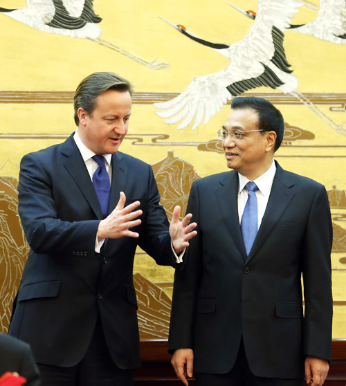 Premier Li Keqiang and British Prime Minister David Cameron chat at a signing ceremony in the Great Hall of the People in Beijing on Monday. They agreed to push companies for breakthroughs in high-speed railway and nuclear power cooperation. WU ZHIYI / CHINA DAILY