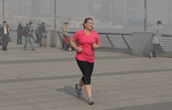 A foreign jogger frowns as she does her morning exercise on The Bund in Shanghai on Monday morning. Gao Erqiang / China Daily