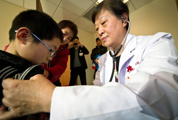 A doctor treats a boy at Tianjin New Century Children's Hospital in Tianjin. The hospital, which opened last year, is the first private hospital for children in the city. Yue Yuewei / Xinhua