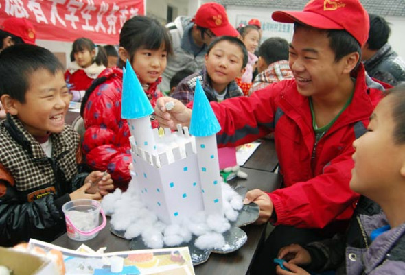 Student volunteers from Jiangsu University of Science and Technology play with children in Jinhe, Jiangsu province. The children were left behind by migrant worker parents who have traveled to cities to work. Shi Yucheng / For China Daily
