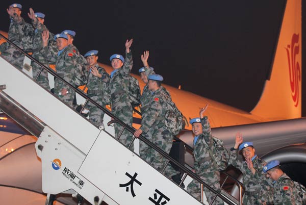 Chinese peacekeeping troops board a plane at the international airport in Harbin, capital of Heilongjiang province, on Tuesday evening. The contingent of 35 engineers, 65 medical workers and 35 soldiers from the People's Liberation Army will serve an eight-month mission in Mali. Wang Jing / China Daily