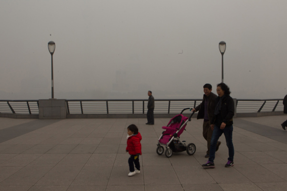 People walk on The Bund in heavily polluted air on Friday. The air quality index in the city topped 400, indicating severe pollution hazardous to health.[PHOTOS BY GAO ERQIANG / CHINA DAILY]