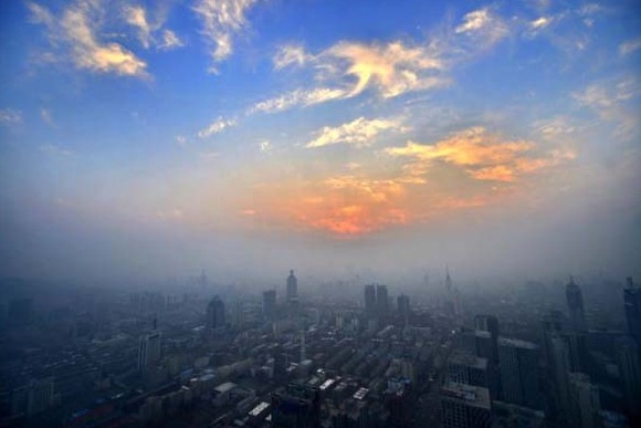 Photo taken on Dec. 7, 2013 shows that the city of Jinan, capital of east China's Shandong Province, was continually shrouded by heavy haze while sunset glow tinted the sky red. (Source: xinhuanet.com) 