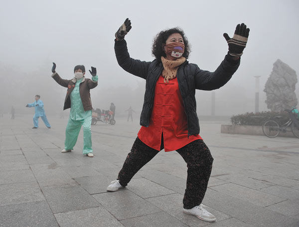 Morning exercisers brave heavy smog in Fuyang, Anhui province, on Sunday. Nearly half of the country is choked in some of the worst air this year. LU QIJIAN / FOR CHINA DAILY