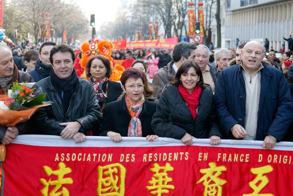 Paris Deputy Mayor and Socialist Party candidate for the 2014 municipal elections Anne Hidalgo (second right) and Jean-Marie Le Guen (right), a member of the Foreign Affairs Committee of the French National Assembly, are among a group of celebrities to participate a carnival celebrating the Chinese New Year in February in the 13th district of Paris. [LONG JIANWU / CHINA NEWS SERVICE]