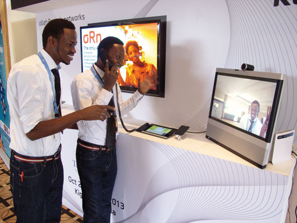 Two Africans try a visual phone at a recent exhibition in Rwanda. Li Lianxing / China Daily