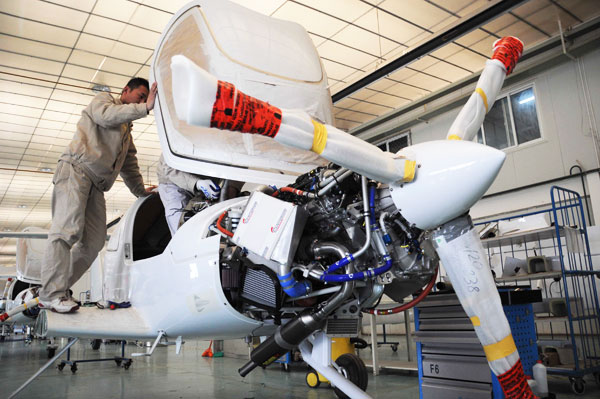 A worker from an aircraft manufacturer assembles an airplane in Binzhou, Shandong province, in March. Experts say the new pilot requirements will encourage more people to take up flying. ZHANG BINBIN / FOR CHINA DAILY