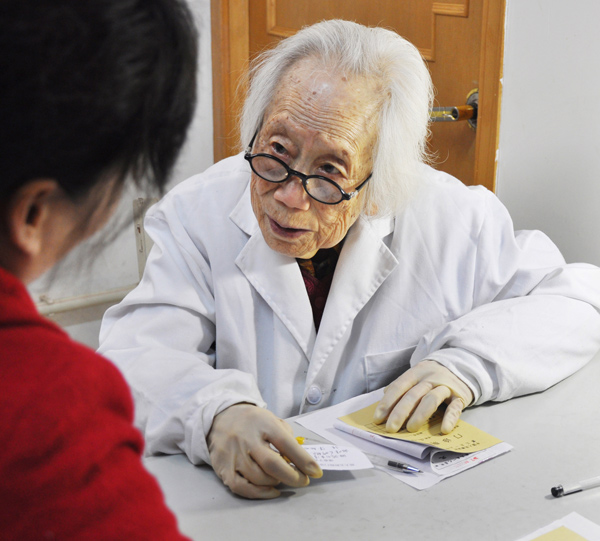 A 97-year-old gynecology specialist, Hu Peilan, gives a patient medical advice on April 12, 2013, in Zhengzhou, Central China's Henan province. Hu is regarded as one of China's oldest doctors and earns praise for her medical skills.