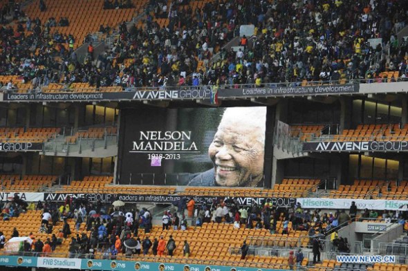People arrive for the memorial service for former South African President Nelson Mandela at the FNB Stadium in Soweto, near Johannesburg, South Africa, Dec. 10, 2013. (Xinhua/Li Qihua)