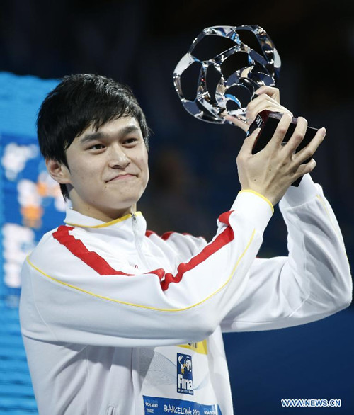 Sun Yang of China poses with the FINA trophy for best male swimmer at the 15th FINA World Championships in Barcelona, Spain, Aug 4, 2013. (Xinhua/Wang Lili)