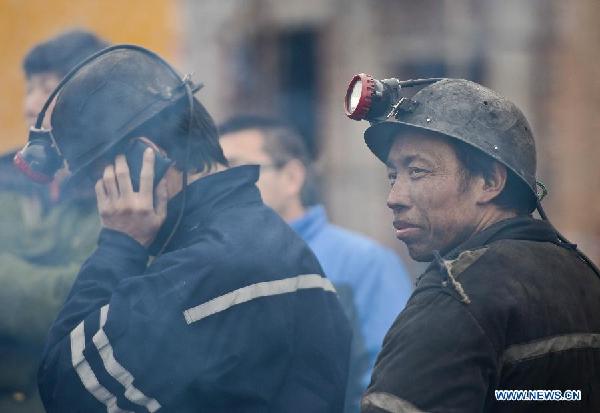 Two coal mine workers take a break at the accident site where a gas explosion happened at the Yangjiagou coal mine in Hutubi County in northwest China's Xinjiang Uygur Autonomous Region, Dec. 13, 2013. The explosion occurred at 1:26 a.m. when 34 miners were working underground. Twelve workers managed to escape themselves. Among the trapped twenty two workers, twenty one were confirmed dead, said the region's emergency response office. (Xinhua/Zhao Ge)