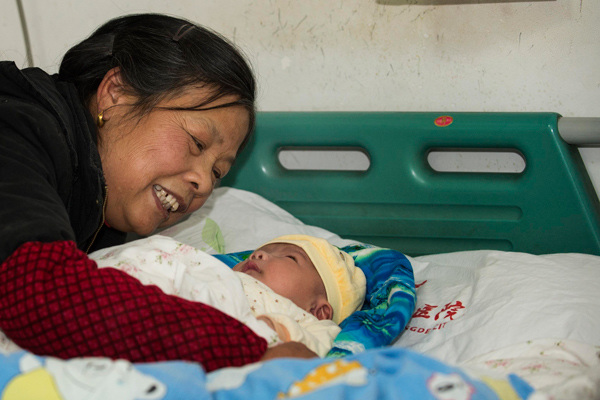A grandmother smiles after her grandchild, who had developed adverse symptoms after being vaccinated for hepatitis B, has responded to treatment in Changde, Hunan province, on Thursday.[Xie Changgui / for China Daily]