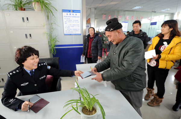 A man's <i>hukou</i> (household registration) is transferred at a government service center in Sanhe, Hebei province. The Ministry of Public Security and 11 other ministries and commissions have drafted reform guidelines aimed at establishing a new system to allow hukou to be transferred based on a person's place of residence and occupation. LI XIAOGUO / XINHUA