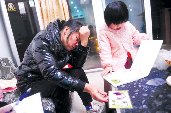 Xinyuan's grandmother and sister look at photos of the toddler. 