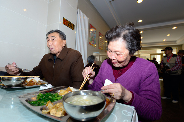 Two senior citizens eat at a restaurant in Lanzhou, Gansu province, in 2012. They ordered their meals through a virtual nursing home, which offers discount prices to elderly people.[Pei Qiang/ for China Daily]