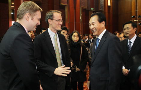 At a New Year media-relations reception in Beijing on Dec 19, Cai Mingzhao (second from right), minister of the State Council Information Office, speaks with Don Durfee (second from left), North Asia general manager of Reuters news agency, and Jason Subler, the China bureau chief for Reuters.[Zou Hong / China Daily]