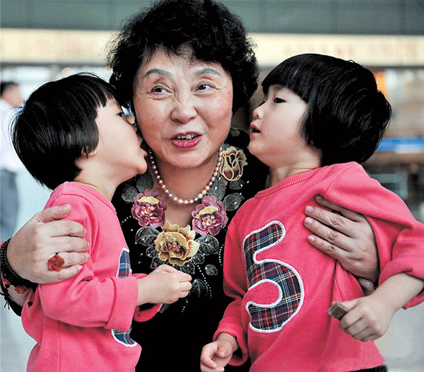 Sheng Hailin gets a kiss from one of her twin daughters born using in vitro technology in this photo circulated online. Sheng gave birth to the twins at the age of 60, becoming Chinas oldest mother of newborns in 2010 following the death of her daughter.