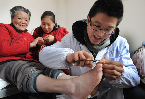 A male nurse gives a pedicure to an elderly woman at a nursing home in Taixing, Jiangsu province, in 2012. He had been working in the nursing home for five years. Many patients' families prefer male caregivers, but turnover is high because of the low pay. LUO ZHONGMING / FOR CHINA DAILY