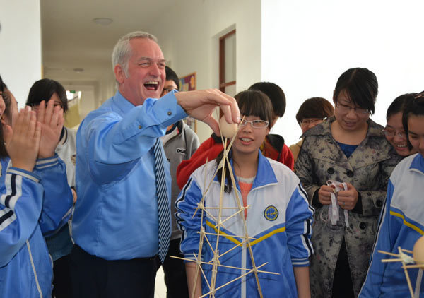 Students and teachers participate in an activity encouraging creative thinking by placing eggs on a structure of sticks, at Tianjin Foreign Languages School. The high school tries to produce well-rounded graduates using an international curriculum. Provided to China Daily