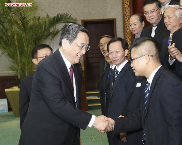 Yu Zhengsheng, chairman of the National Committee of the Chinese People's Political Consultative Conference (CPPCC), shakes hands with media representatives attending a cross-Strait press forum in Beijing, capital of China, Dec. 22, 2013. (Xinhua/Ding Lin)