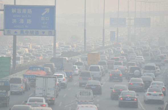 Vehicles move along a road during heavy smog in the city of Tianjin, North China, Dec 23, 2013. [Photo/Xinhua]
