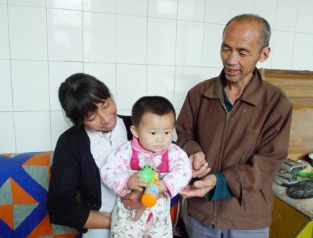 Su Meiling and her father-in-law play with her second child at their home in Yicheng county, Shanxi province. Su and her husband Qiao Weijie had the daughter last year. Xu Wei / China Daily