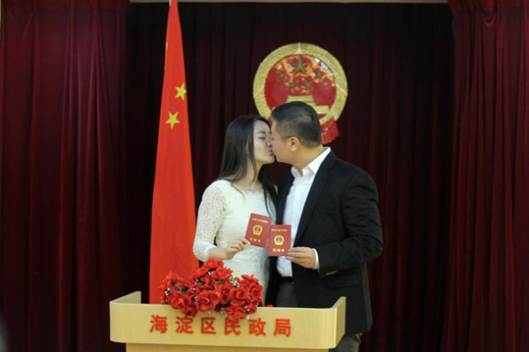 A couple celebrate their marriage after completing registration procedures in Beijing on Friday. Many couples chose to marry on Friday, as the pronunciation of 1413 (Jan 3, 2014) in Chinese is similar to yi shi yi sheng (love you for a lifetime). [Photo by Wang Jing/Asianewsphoto]