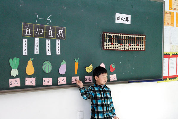 Tian Xingjian, 5, calculates on the abacus on the blackboard at the preschool attached to the Beijing Bright Horizon International Academy primary school. (Photo: China Daily)